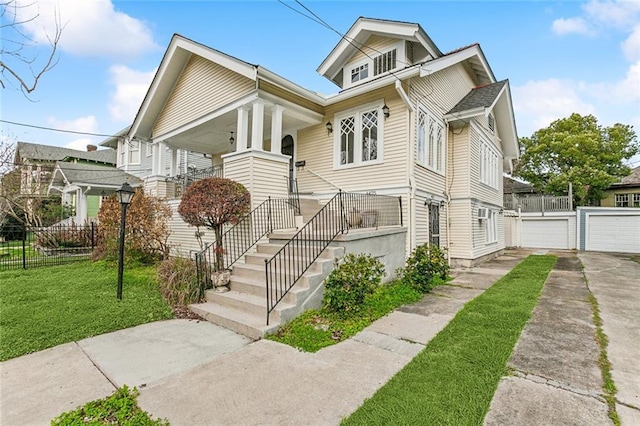 bungalow-style house featuring a garage, an outbuilding, a front yard, and fence