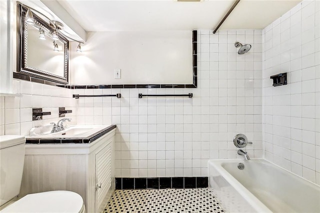 bathroom with shower / bath combination, vanity, toilet, and tile walls