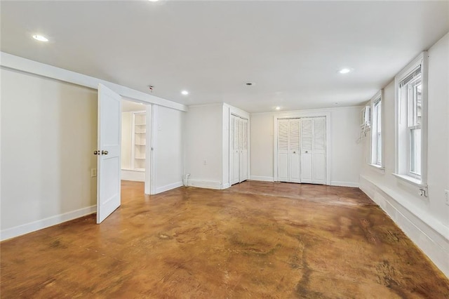 spare room with recessed lighting, finished concrete flooring, and baseboards