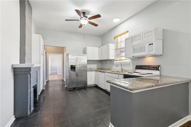 kitchen featuring white appliances, a sink, ceiling fan, a peninsula, and light stone counters
