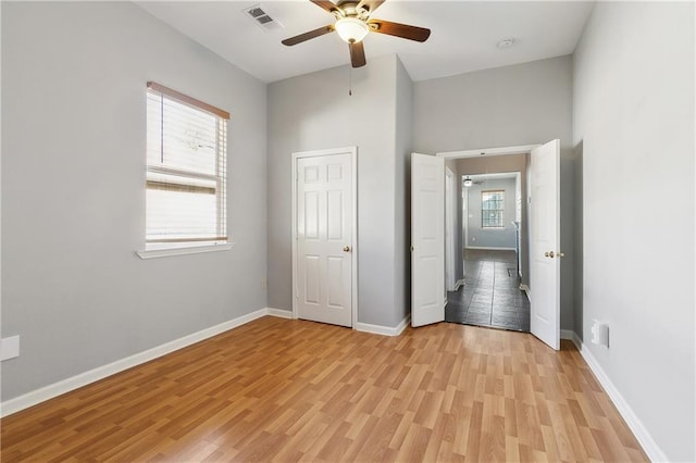 unfurnished bedroom with light wood finished floors, baseboards, and ceiling fan