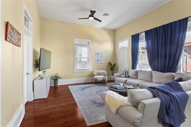 living room with visible vents, plenty of natural light, baseboards, and dark wood-style flooring