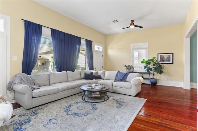 living room featuring visible vents, plenty of natural light, baseboards, and dark wood-style flooring