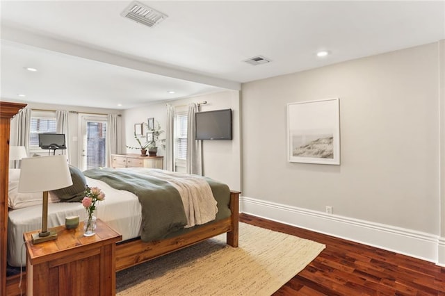 bedroom featuring dark wood-type flooring, multiple windows, baseboards, and visible vents