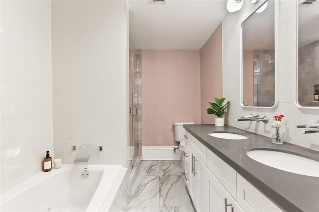 full bathroom with a sink, a garden tub, marble finish floor, and a shower stall