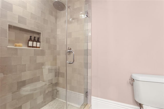 bathroom with a shower stall and toilet