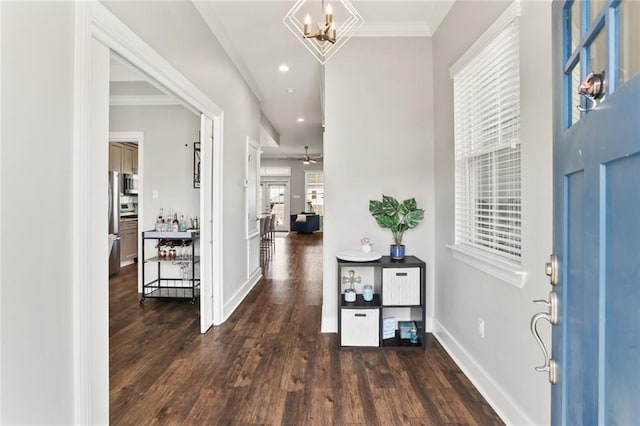 entryway with ornamental molding, ceiling fan with notable chandelier, wood finished floors, recessed lighting, and baseboards