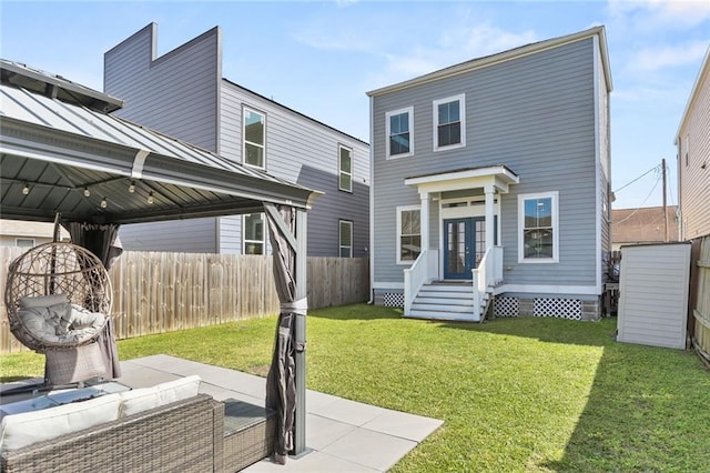 back of property featuring a lawn, a standing seam roof, fence, a gazebo, and metal roof