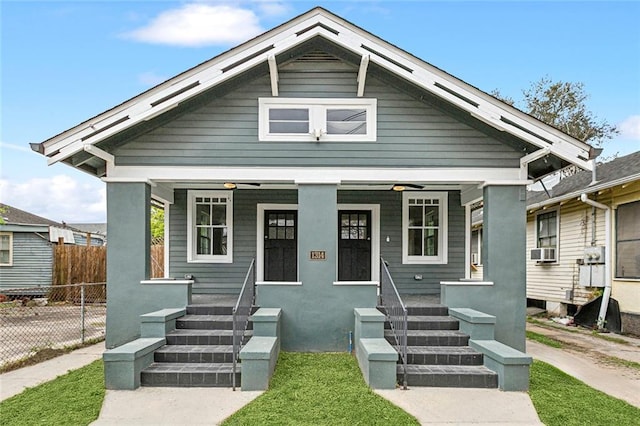 bungalow with cooling unit, fence, and covered porch