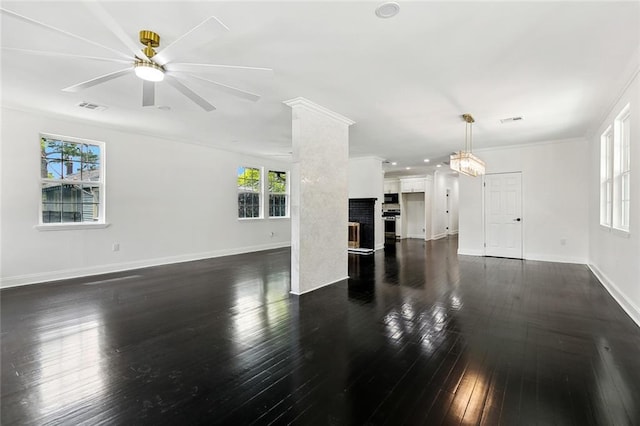 living room featuring a fireplace, visible vents, dark wood-style flooring, and ornamental molding