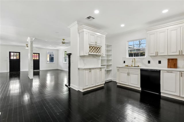 kitchen featuring visible vents, dark wood-type flooring, a sink, black dishwasher, and light countertops