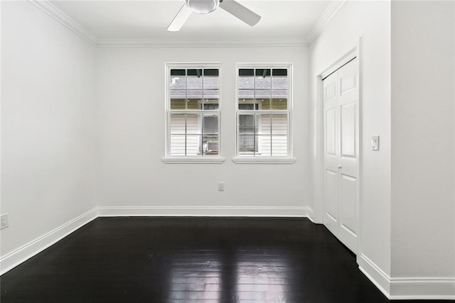 spare room featuring baseboards, a ceiling fan, dark wood-style floors, and crown molding