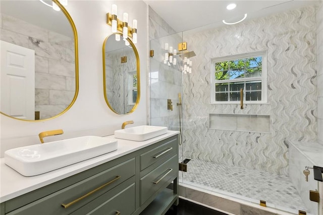 full bath featuring double vanity, a tile shower, and a sink