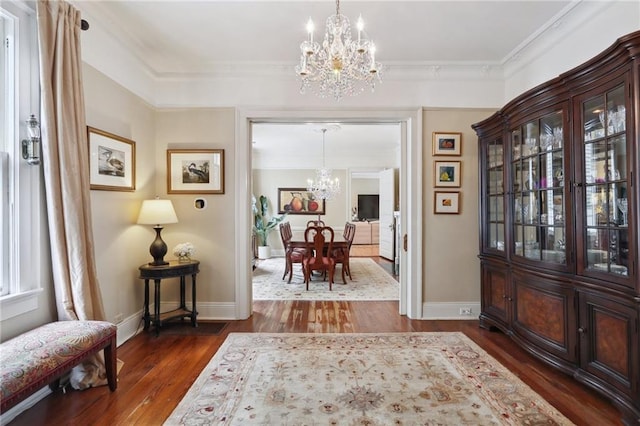 entryway with dark wood-style floors, baseboards, a chandelier, and crown molding