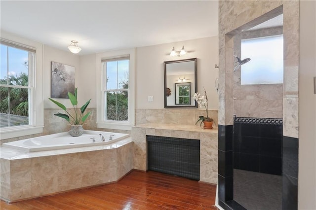 bathroom featuring wood-type flooring, plenty of natural light, and a bath