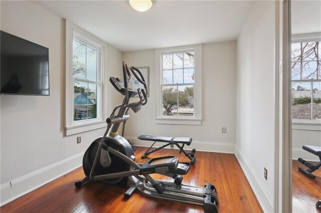 workout room featuring baseboards and wood-type flooring