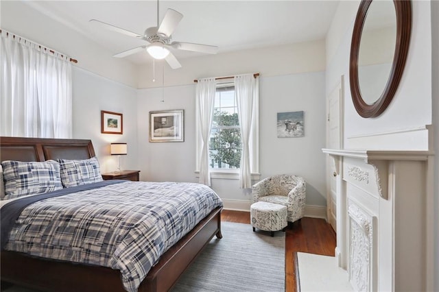 bedroom with ceiling fan, baseboards, and wood finished floors