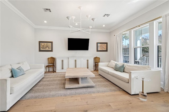 living area with light wood-type flooring, visible vents, and ornamental molding