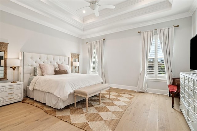 bedroom with light wood finished floors, baseboards, ornamental molding, recessed lighting, and a raised ceiling