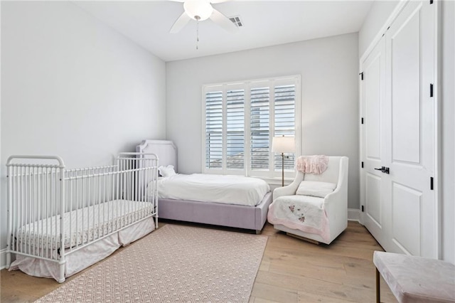 bedroom with visible vents, light wood-style floors, a closet, and ceiling fan