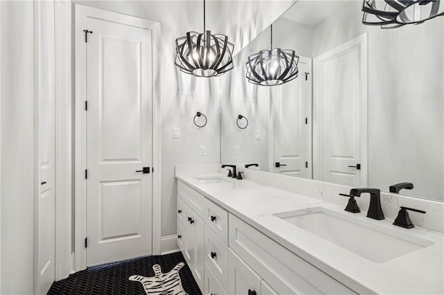 full bath featuring a chandelier, tile patterned flooring, double vanity, and a sink