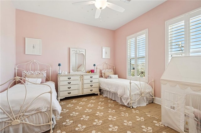 bedroom with light wood-style flooring, baseboards, and ceiling fan