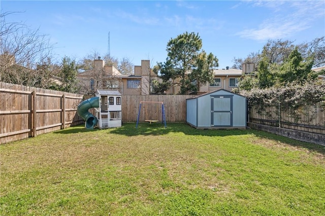 view of yard featuring an outdoor structure, a playground, a storage unit, and a fenced backyard