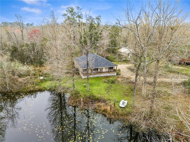 drone / aerial view with a wooded view and a water view