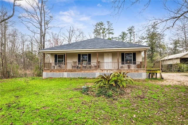 view of front of house with stucco siding, a porch, driveway, and a front lawn