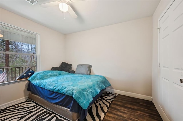 bedroom featuring visible vents, a ceiling fan, baseboards, and wood finished floors