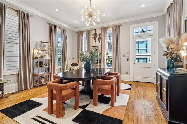 dining space featuring baseboards, light wood-style floors, a chandelier, and ornamental molding