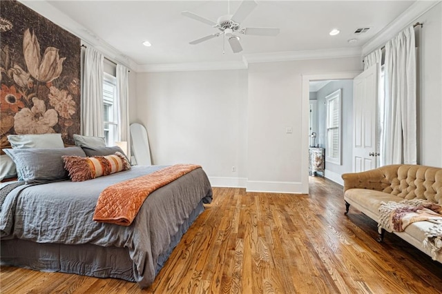 bedroom featuring visible vents, wood finished floors, baseboards, and ornamental molding