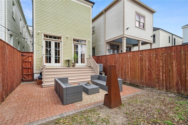 rear view of property with a patio area, french doors, an outdoor living space, and a fenced backyard