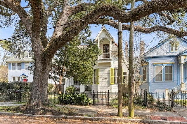 view of front facade featuring a fenced front yard and a balcony