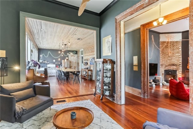 living area with a notable chandelier, a fireplace, and wood finished floors