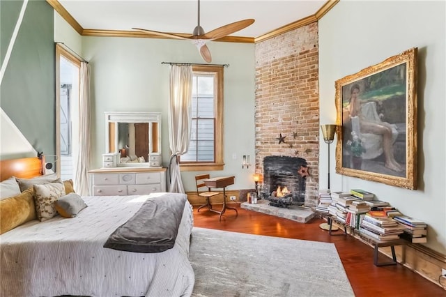 bedroom with a brick fireplace, wood finished floors, and ornamental molding