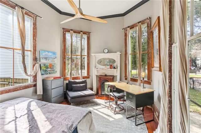 bedroom with a ceiling fan, wood finished floors, crown molding, and access to outside