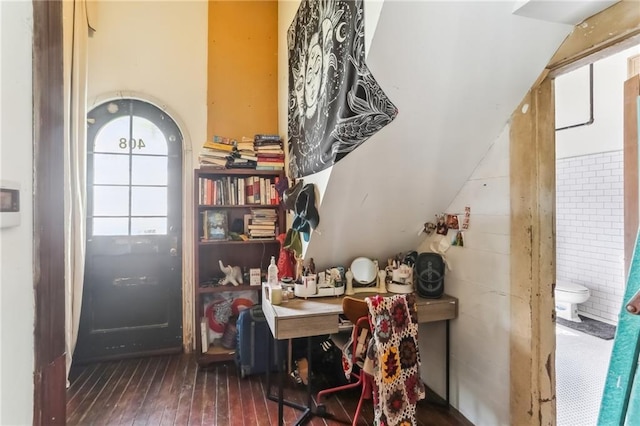 home office featuring wood-type flooring and arched walkways