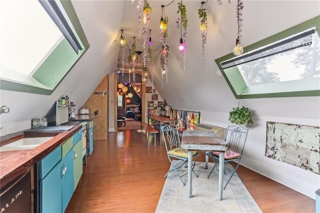 interior space featuring a sink, lofted ceiling with skylight, and wood finished floors