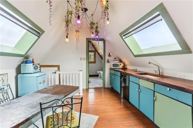 kitchen with lofted ceiling with skylight, dishwashing machine, light wood-style flooring, wood counters, and a sink