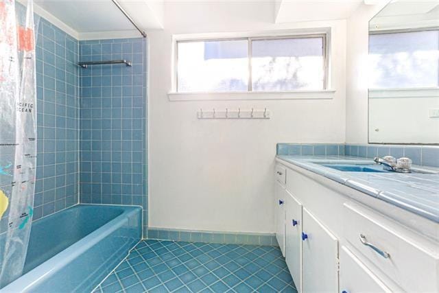 bathroom featuring tile patterned floors, vanity, and shower / tub combo with curtain