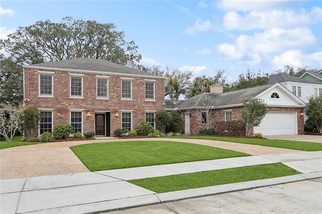 colonial inspired home featuring brick siding, a front yard, an attached garage, and driveway