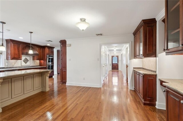 37 Spanish Fort Blvd, New Orleans, LA 70124 - kitchen with visible vents, light wood-style flooring, stainless steel double oven, wall chimney exhaust hood, and decorative backsplash