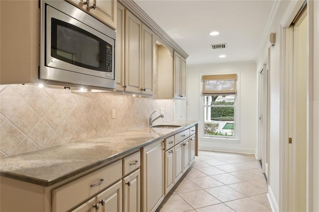 37 Spanish Fort Blvd, New Orleans, LA 70124 - kitchen with stainless steel microwave, cream cabinets, visible vents, and a sink