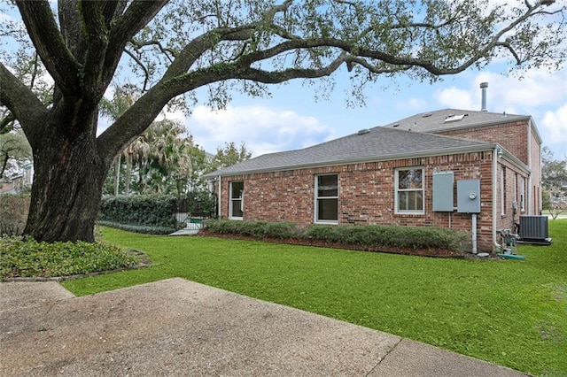 37 Spanish Fort Blvd, New Orleans, LA 70124 - view of side of property featuring a yard, central air condition unit, brick siding, and roof with shingles