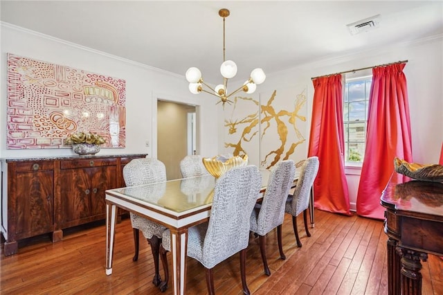 3205 Octavia St, New Orleans, LA 70125 - dining area with a chandelier, wood-type flooring, and ornamental molding