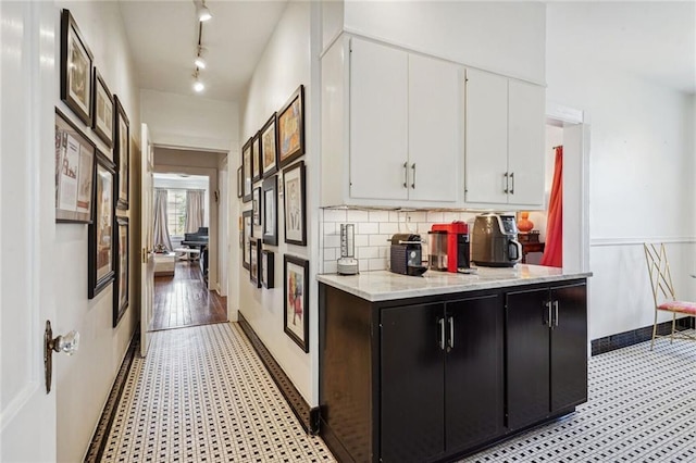 3205 Octavia St, New Orleans, LA 70125 - kitchen featuring light flooring, white cabinets, backsplash, light stone countertops, and rail lighting