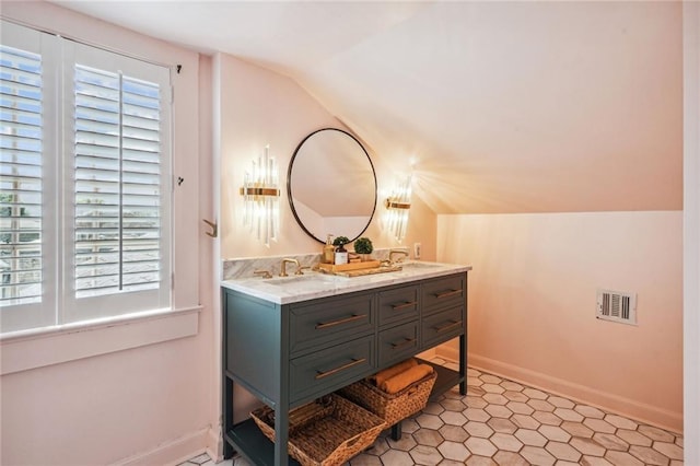 3205 Octavia St, New Orleans, LA 70125 - bathroom featuring lofted ceiling, double vanity, baseboards, and tile patterned floors