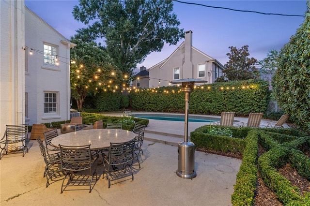 3205 Octavia St, New Orleans, LA 70125 - patio terrace at dusk featuring a patio area, outdoor dining space, and a fenced backyard