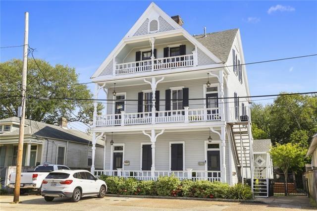 victorian home with stairway, a porch, and a balcony